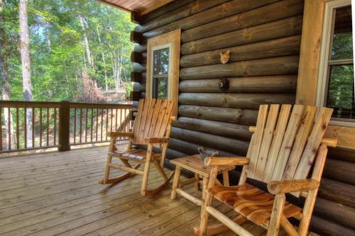 two rocking chairs on a porch of a cabin at Honeymoon Getaway in woods near NOC and Smoky Mtn RR in Bryson City