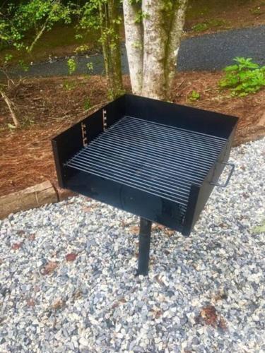 a black bench sitting on top of gravel at Honeymoon Getaway in woods near NOC and Smoky Mtn RR in Bryson City