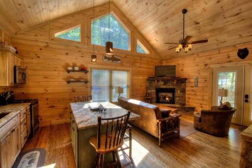 a kitchen and living room of a log cabin at Honeymoon Getaway in woods near NOC and Smoky Mtn RR in Bryson City