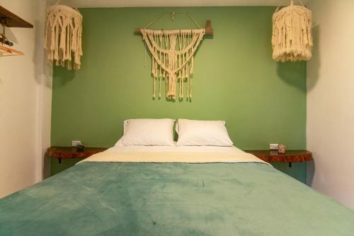 a bed in a room with a green wall at Waikiki beach Hotel Boutique in Dibulla
