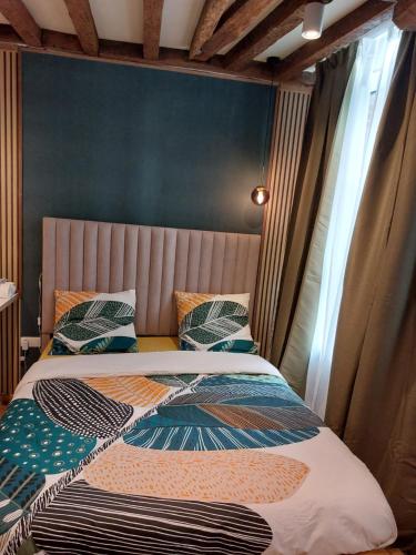a bedroom with a bed with a bedspread on it at Le rustiques Moderne de la Raquette in Mons
