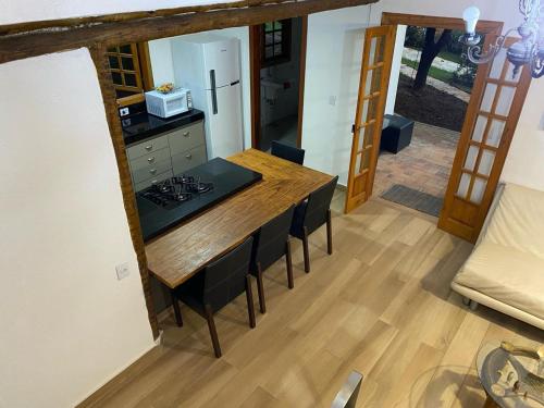 a kitchen with a wooden table and a counter top at Casa de Campo Pampulha in Belo Horizonte