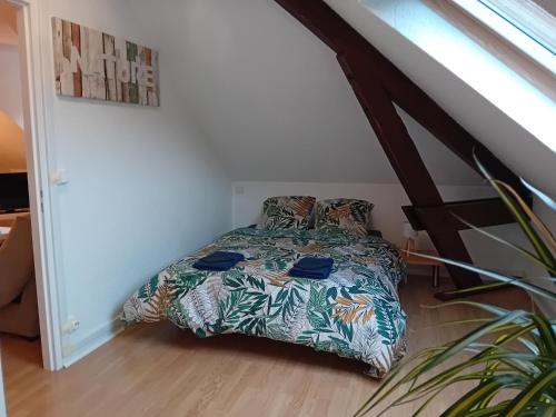 a bedroom with a bed with a comforter on it at Appartement vallée de Campan in Campan