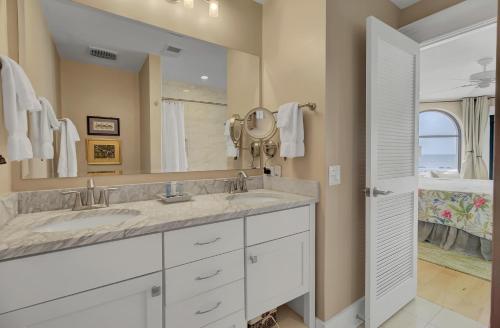 a bathroom with two sinks and a large mirror at 211 Seascape by AvantStay Oceanfront View Pool in Isle of Palms