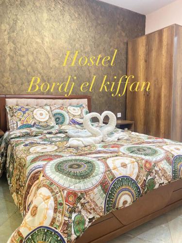 a bedroom with a bed with aoked board el at HOSTEL BORDJ ELKIFFAN in Fort de lʼEau