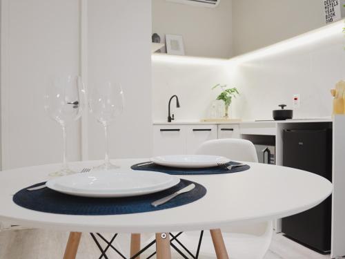 a white table and chairs in a white kitchen at Apê Metrô Paraíso in São Paulo