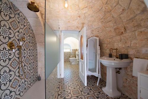 ein Bad mit einem Waschbecken und einem WC in der Unterkunft Trullo Imperiale in Cisternino