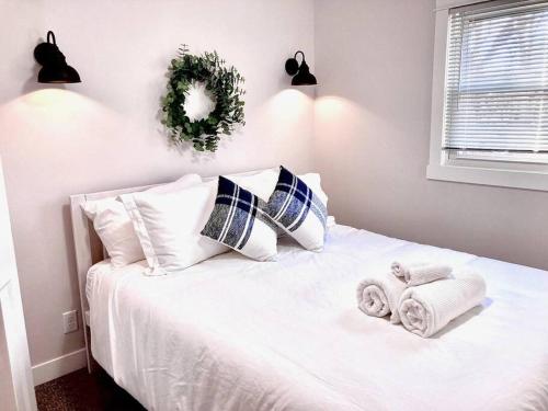a bedroom with a white bed with towels on it at The Cove by the North Shore in Forest Lake