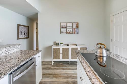 a kitchen with marble counter tops and a sink at Salt and Light Oceanfront Condo with Pool and Elevator in Ocean Isle Beach