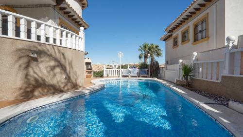 a swimming pool in the side of a house at Amazing villa ideal for golf or family holidays in Villamartin