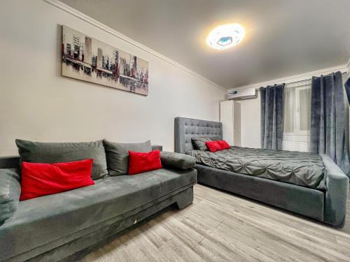 a living room with a couch and a bed at Luxor - Jacuzzi&Cozy Apartments in Sibiu