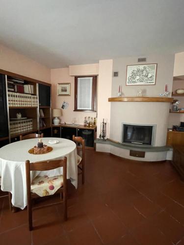 a living room with a table and a fireplace at Pian della Battaglia in Anghiari