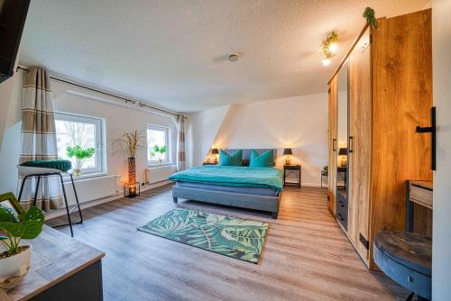 ein Schlafzimmer mit einem Bett mit blauen Kissen in der Unterkunft Zuarin Schlossblick - Ganzes Apartment direkt am Schlossgarten von Schwerin mit Dschungel-Feeling - Parkplatz auf Anfrage vorhanden in Schwerin