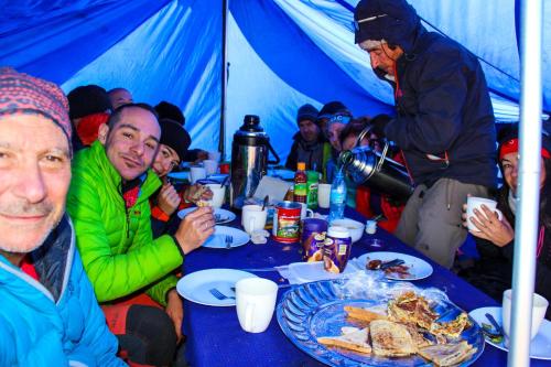 Eine Gruppe von Menschen, die an einem Tisch sitzen und Essen essen. in der Unterkunft Mogli Adventure safari in Moshi