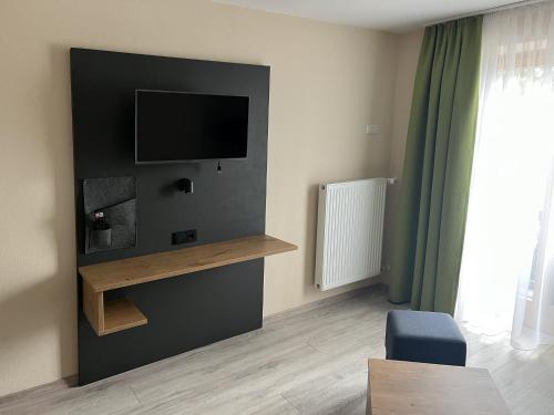 a living room with a flat screen tv on a wall at Alpengasthof Hochberg - Familie Gruber in Traunstein