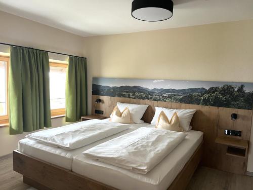 um quarto com uma grande cama branca com cortinas verdes em Alpengasthof Hochberg - Familie Gruber em Traunstein