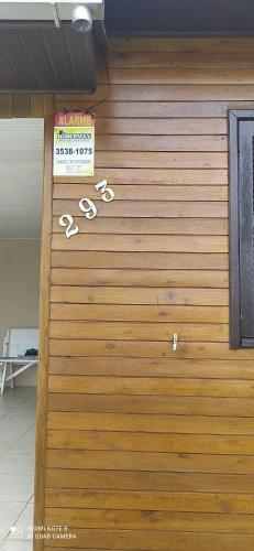 a wooden garage door with a sign on it at Casa de Praia. Lugar sossegado para recarregar as energias. in Passo de Torres