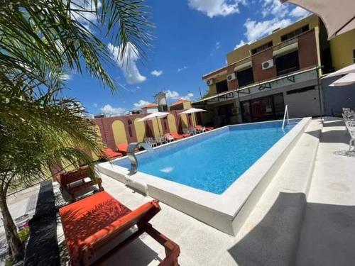 a swimming pool in front of a building at Hotel Santander in Termas de Río Hondo