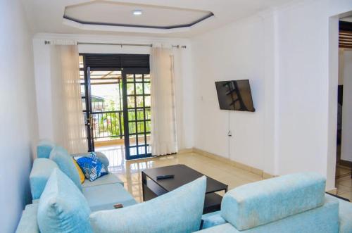 a living room with blue furniture and a tv at One Love Hotel in Kigali