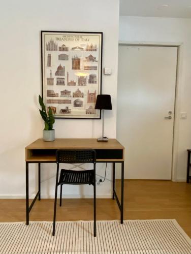 a desk with a chair and a picture on the wall at Tranquil studio near nature, free parking& wifi in Helsinki