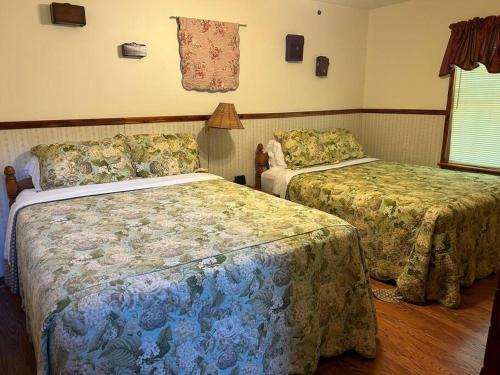 a hotel room with two beds and a window at Deluxe Cabin #17 with Jacuzzi on Patoka Lake in Southern Indiana in Paoli