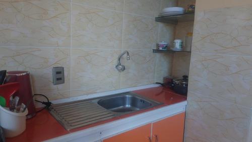 a kitchen with a sink and a red counter top at habitación privada y confortable in La Paz