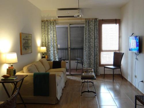 ein Wohnzimmer mit einem Sofa und einem TV in der Unterkunft Best location ! Apt priv de 2 hab c AC Completamente equipado en Asuncion in Asunción