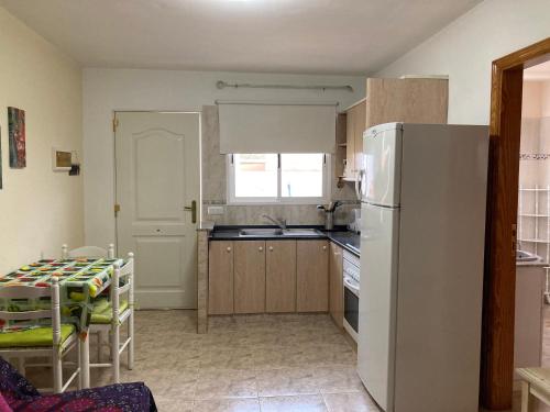 uma cozinha com um frigorífico branco e uma mesa em Casa Aloe C. Las Playitas. em Las Playitas