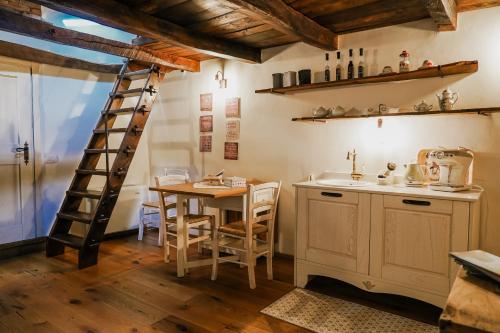 una cocina con una mesa de madera y una escalera en B&B e Home Restaurant S'ispera Monolocale uso esclusivo, en Fonni
