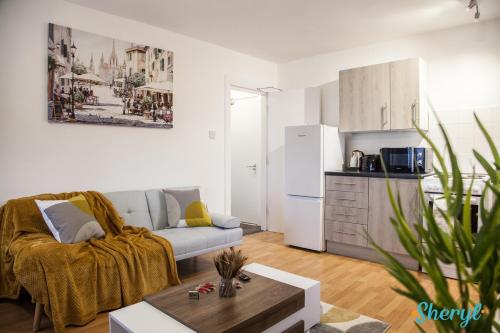 a living room with a couch and a kitchen at Liverpool City Flat 4 by Sheryl - Close to City Center, Anfield Stadium and Airport with free business super fast fibre broadband in Liverpool