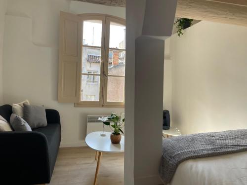 a living room with a couch and a table at Le Mini - Un voyage en Provence in Aix-en-Provence