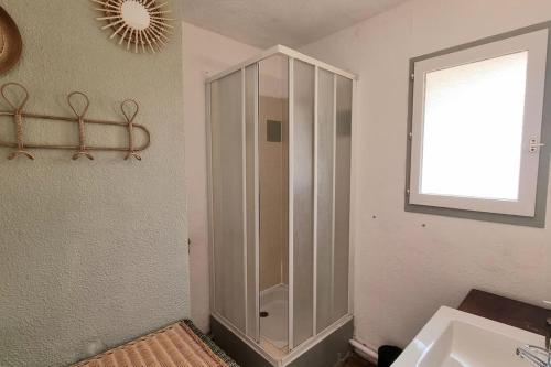 een badkamer met een douche, een wastafel en een spiegel bij Chez K&D Studio by Amel in Saint-Raphaël