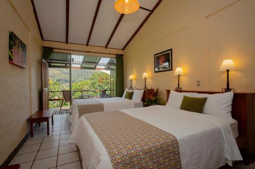 una camera d'albergo con due letti e una finestra di Arenal Observatory Lodge & Trails a Fortuna