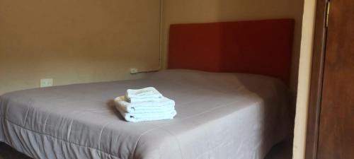 a pile of towels sitting on top of a bed at La Morada Hostal in Cafayate