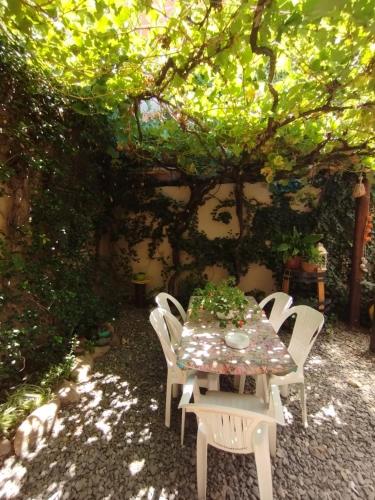 a table and chairs sitting under a tree at La Morada Hostal in Cafayate