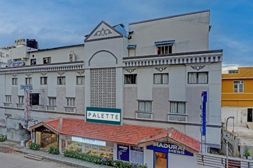 un gran edificio blanco con un cartel. en OYO Palette - Hotel Victoria, en Chennai