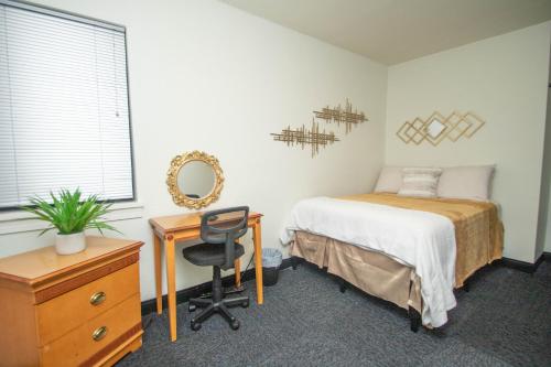 a bedroom with a bed and a desk and a chair at Vintage Elegance - Condo Steps Away from Casino in Hot Springs