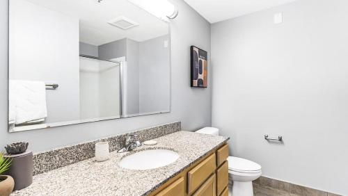 ein Badezimmer mit einem Waschbecken, einem WC und einem Spiegel in der Unterkunft Landing Modern Apartment with Amazing Amenities ID1805X70 in Indianapolis