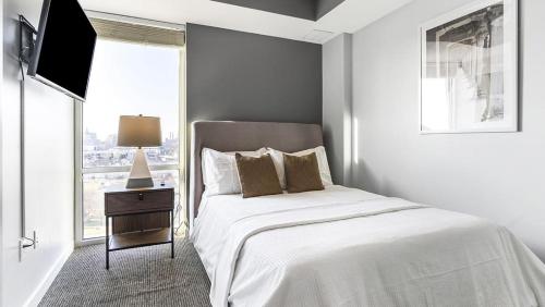 ein weißes Schlafzimmer mit einem Bett und einem Fenster in der Unterkunft Landing Modern Apartment with Amazing Amenities ID1805X70 in Indianapolis