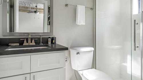 a white bathroom with a toilet and a sink at Landing Modern Apartment with Amazing Amenities (ID1803X66) in Mobile