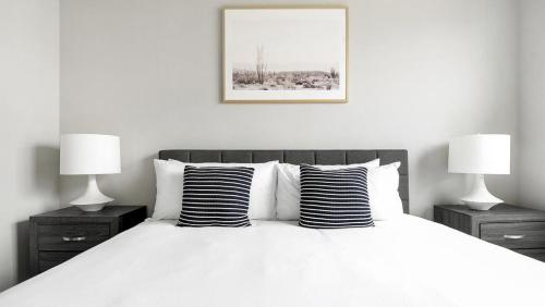 een slaapkamer met een wit bed en 2 lampen bij Landing Modern Apartment with Amazing Amenities (ID1802X54) in Austin