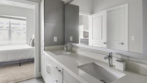 een witte badkamer met 2 wastafels en een bed bij Landing Modern Apartment with Amazing Amenities (ID1802X54) in Austin