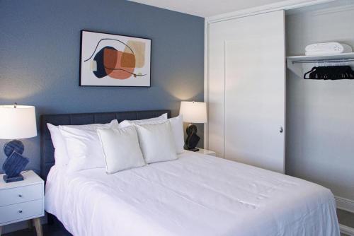 een slaapkamer met een groot wit bed met 2 lampen bij Landing Modern Apartment with Amazing Amenities ID1804X47 in St Petersburg