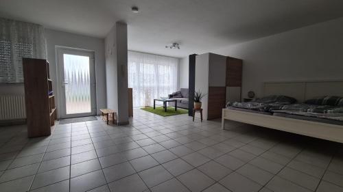 a large room with a bed and a living room at Ruhige Ferienwohnung am Rande des Nordschwarzwalds in Straubenhardt
