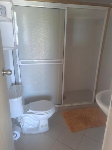 a white bathroom with a toilet and a sink at posada sunrise view vacation home in Providencia