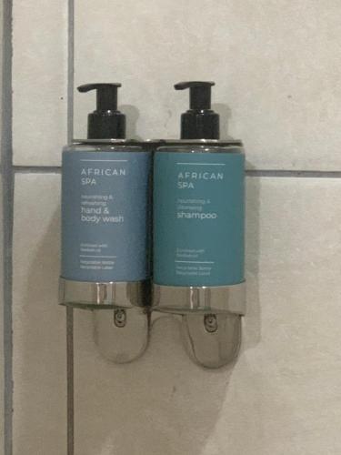 dos botellas azules de jabón colgando en una pared en The Leslie - Bed & Breakfast, en Blantyre