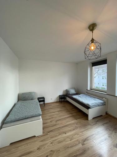 Cette chambre comprend 2 lits et une fenêtre. dans l'établissement Wohnung in Stadtnähe Düren, à Düren
