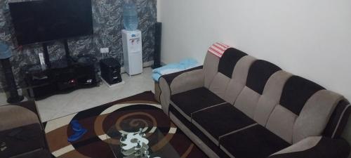 uma sala de estar com um sofá e uma mesa em Samanah air bñb em Nakuru
