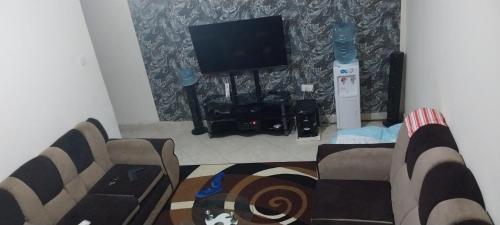 uma sala de estar com um sofá e uma televisão de ecrã plano em Samanah air bñb em Nakuru