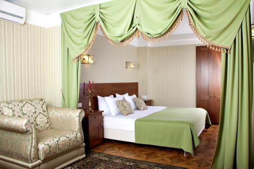 コストロマにあるMoskovskaya Zastava Hotelのベッドと椅子付きのホテルルーム
